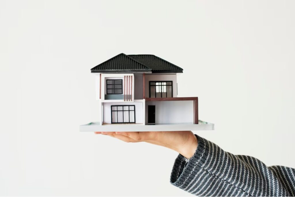 Hand presenting model house for getting a house with the help of a mortgage broker